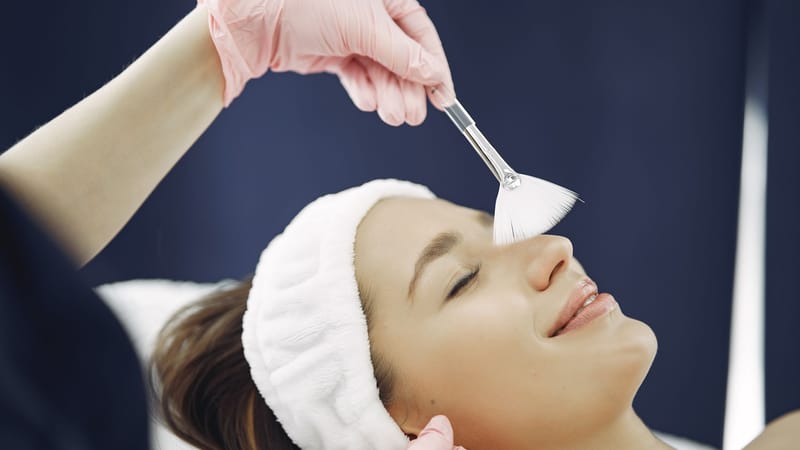 Femme profitant d'un soin du visage relaxant dans un spa, mettant en avant les soins de la peau et la relaxation.