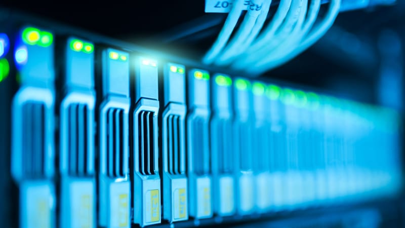 Image détaillée d'un rack de serveurs avec des lumières scintillantes dans un centre de données moderne.