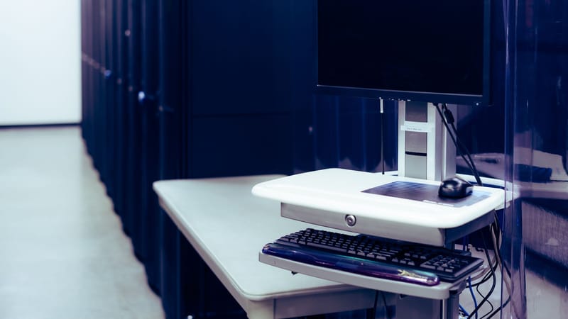 Un centre de données moderne avec une configuration d'ordinateur comprenant un moniteur et un clavier, mettant en avant l'infrastructure technologique.