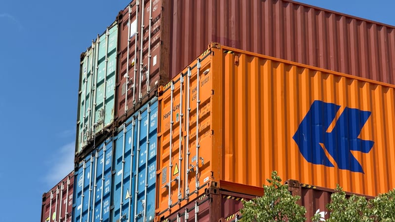 Des conteneurs maritimes colorés sont empilés dans une zone de stockage extérieure en Allemagne.