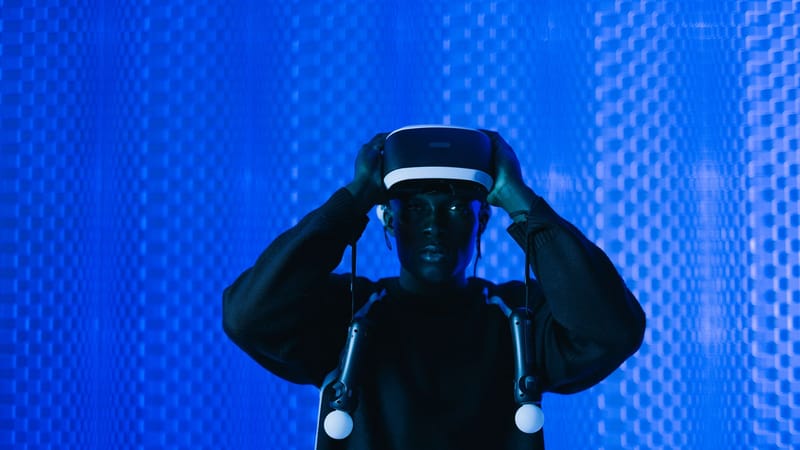 Homme immergé dans la réalité virtuelle utilisant un casque VR dans un environnement dynamique bleu.