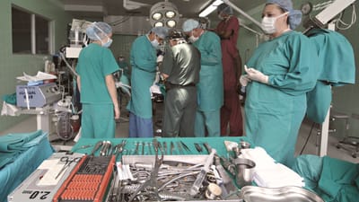 Équipe médicale effectuant une chirurgie dans une salle d'opération stérile avec des instruments chirurgicaux au display.