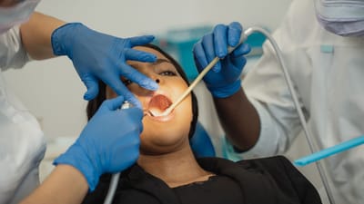 Des professionnels de la santé dentaire effectuant un examen approfondi d'un patient dans un cadre clinique, mettant l'accent sur les soins de santé.