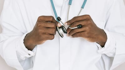 Un médecin professionnel tenant un stéthoscope, se concentrant sur les mains et les outils médicaux.