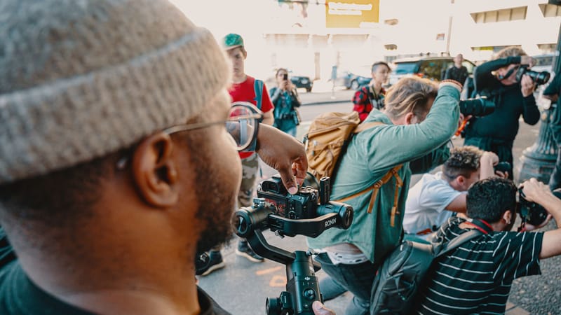 Des photographes se rassemblent dans une rue de la ville pour capturer des clichés dynamiques pendant la journée.