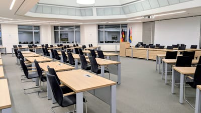 Salle de réunion spacieuse et moderne en Basse-Saxe, en Allemagne, avec bureaux et drapeaux.