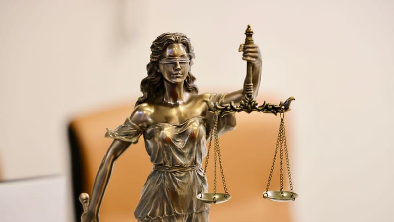 Gros plan de la statue de Lady Justice tenant une balance, symbolisant la justice et l'équité.