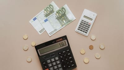 Vue de dessus de calculatrices et de la monnaie Euro, illustrant les calculs financiers et la gestion de budget.