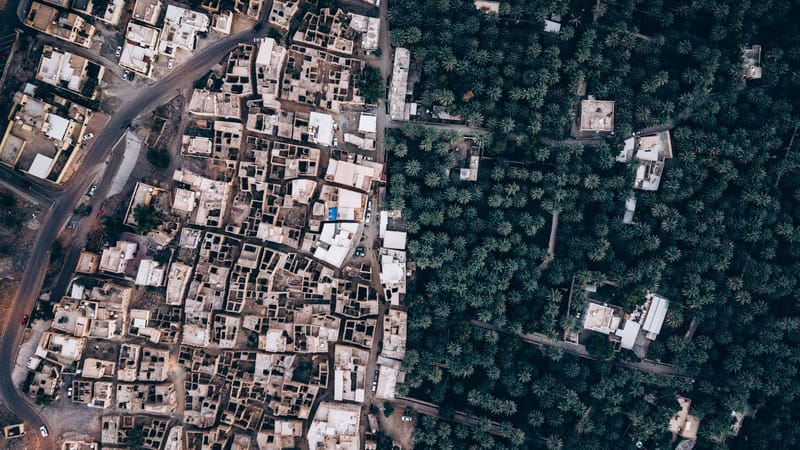 Superbes images aériennes de maisons traditionnelles en terre et de luxuriantes palmeraies à Oman, illustrant un contraste saisissant entre milieu urbain et nature.