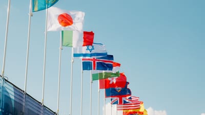 Une rangée de drapeaux internationaux flottant sous un ciel bleu clair à Paris, en France.