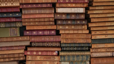 Pile de livres vintage en cuir avec des designs ornés, reflétant l'histoire et la littérature.