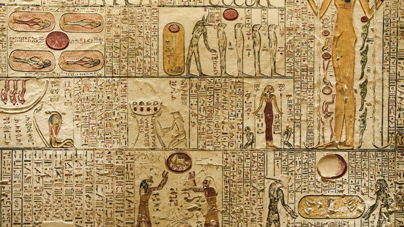 Hiéroglyphes et figures anciennes égyptiennes détaillés sculptés sur un mur de temple.