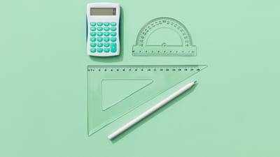 Une composition minimaliste de fournitures scolaires sur un fond vert comprenant une calculatrice, des règles et un crayon.