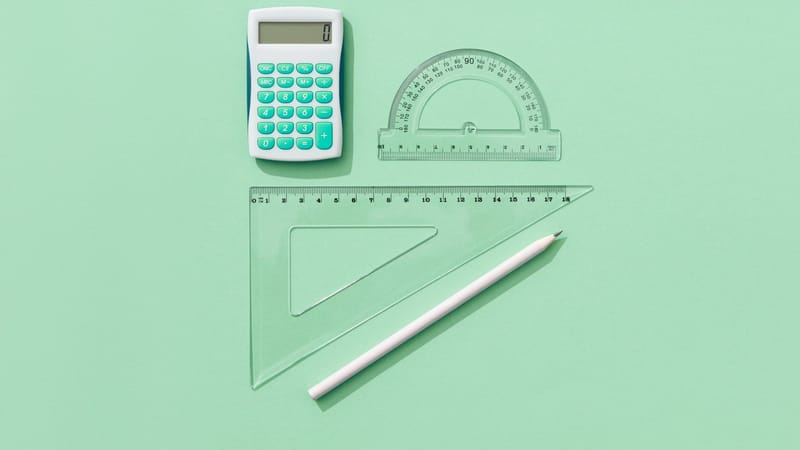 Une composition minimaliste de fournitures scolaires sur un fond vert comprenant une calculatrice, des règles et un crayon.