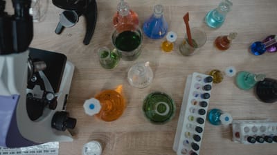 Laboratoire de chimie coloré avec des tubes à essai et un microscope vu de dessus.