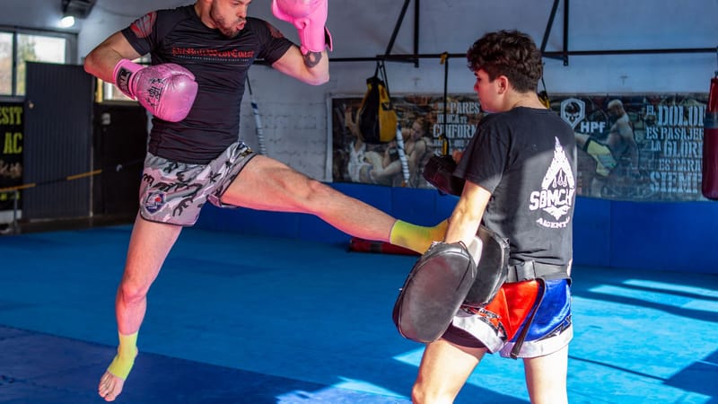 Entraînement dynamique de kickboxing mettant en scène deux hommes en sparring dans une salle de gym.