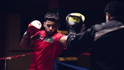 Un boxeur assène un coup de poing lors d'un entraînement sur un ring. Action et concentration captées.