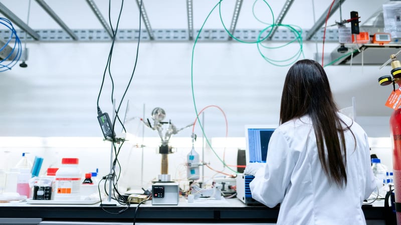 Une scientifique effectuant des recherches dans un laboratoire contemporain rempli d'équipements.