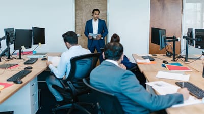 Réunion d'affaires avec une équipe diversifiée dans un espace de bureau moderne, discutant de projets.