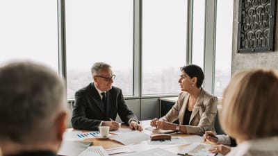 Des professionnels des affaires engagés dans une réunion stratégique dans un bureau moderne avec lumière naturelle.