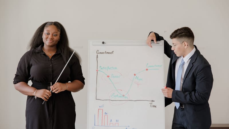 Des professionnels du secteur présentant un graphique lors d'une réunion dans un bureau, soulignant l'esprit d'équipe.
