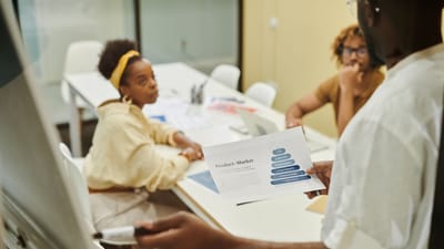 Trois collègues engagés dans une discussion collaborative lors d'une réunion d'affaires.