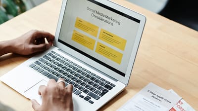 Une personne utilisant un ordinateur portable pour examiner des stratégies de marketing sur les réseaux sociaux à domicile.
