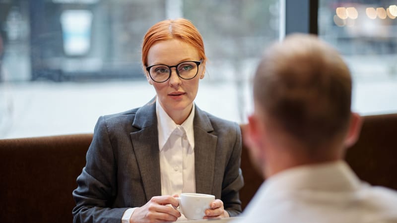 Femme d'affaires lors d'une réunion d'entreprise avec un café dans un cadre décontracté.