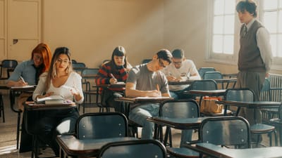 Des étudiants assistent à un cours dans une salle de classe d'une université de Buenos Aires, baignée de lumière naturelle.