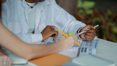Un groupe diversifié d'étudiants collaborant en extérieur, prenant des notes et se préparant pour un projet.