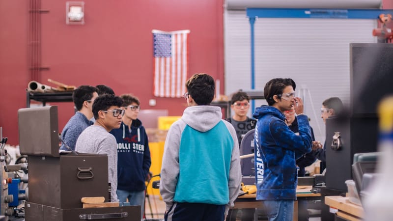 Des adolescents travaillant ensemble dans un atelier éducatif, favorisant le travail d'équipe et l'apprentissage.