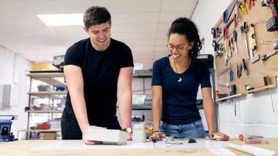 Deux ingénieurs collaborent dans un atelier, s'engageant dans le prototypage et la conception pratiques.