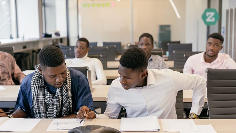 Collègues divers engagés dans une réunion d'équipe, discutant d'idées dans un cadre de bureau moderne.