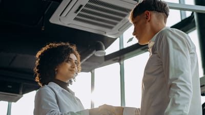 Des professionnels du secteur échangent une poignée de main dans un bureau moderne, symbolisant la collaboration.