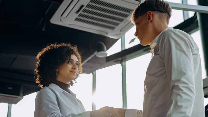 Des professionnels du secteur échangent une poignée de main dans un bureau moderne, symbolisant la collaboration.